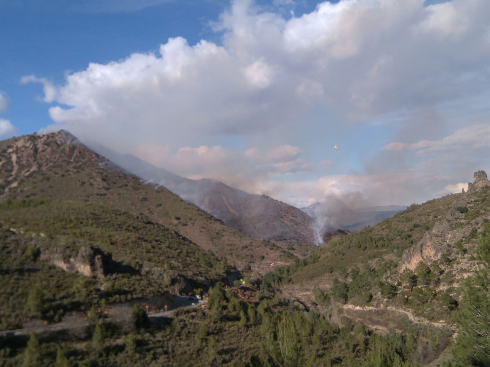 Efectivos aéreos y terrestres de bomberos trabajan en la extinción de un incendio en Montán