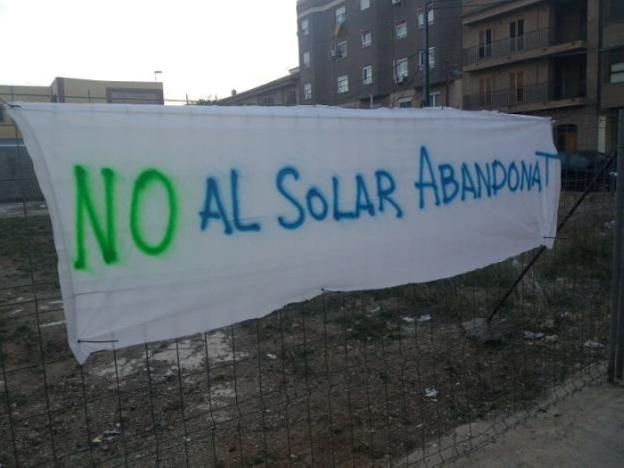 Una pancarta en el solar junto al centro educativo. 