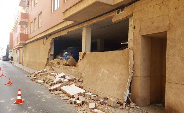 Cinco vehículos afectados por el desprendimiento de 12 metros de muro en un garaje de Alzira