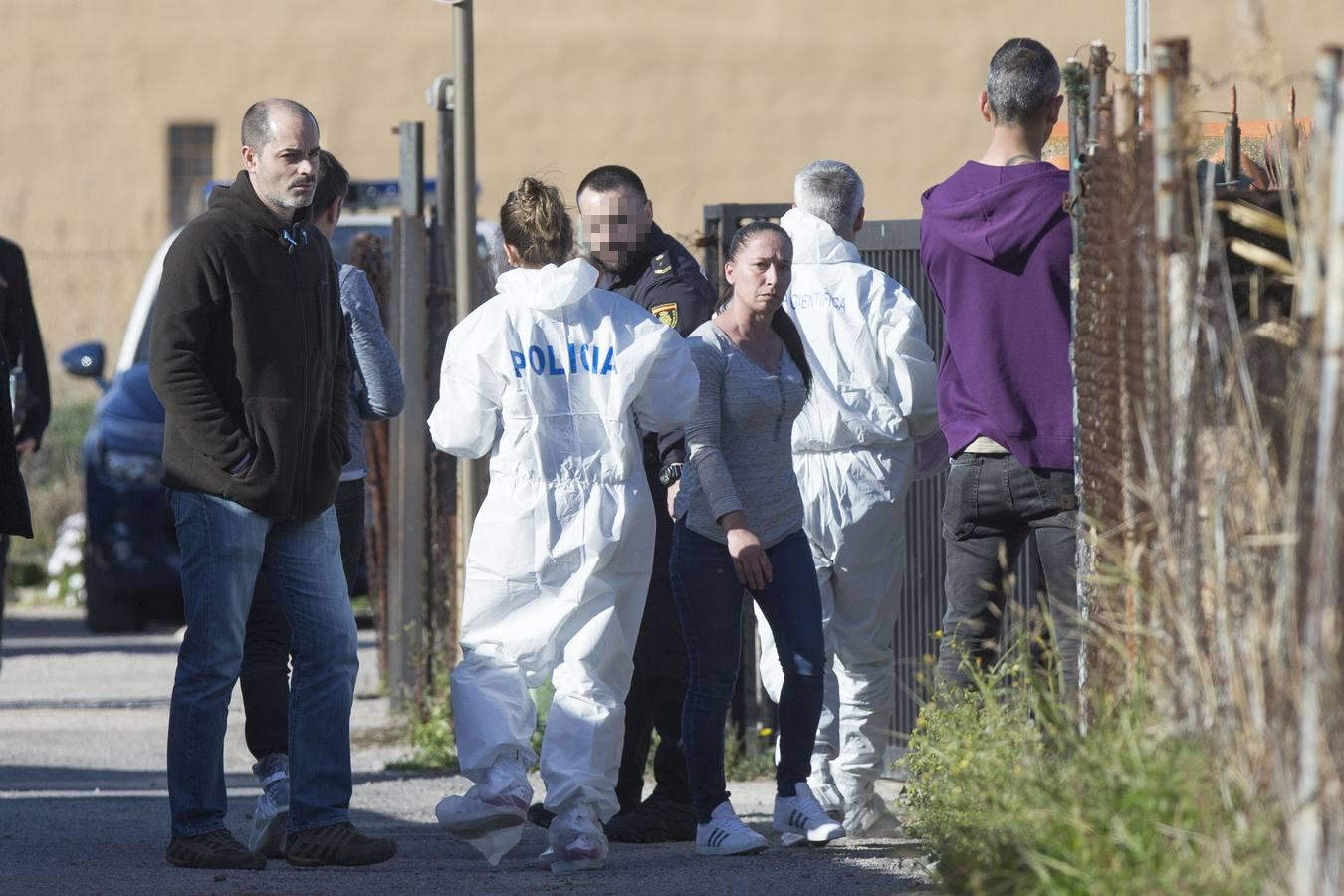 Agentes de la Policia Nacional ante la vivienda junto a la pareja del hombre que supuestamente ha matado con un arma blanca al padre de ésta, en el Grao de Castellón. La mujer le había denunciado por amenazas de muerte y estaba refugiada en un centro de acogida. El arrestado también ha herido a la hija de su expareja, según han confirmado fuentes de la investigación. 