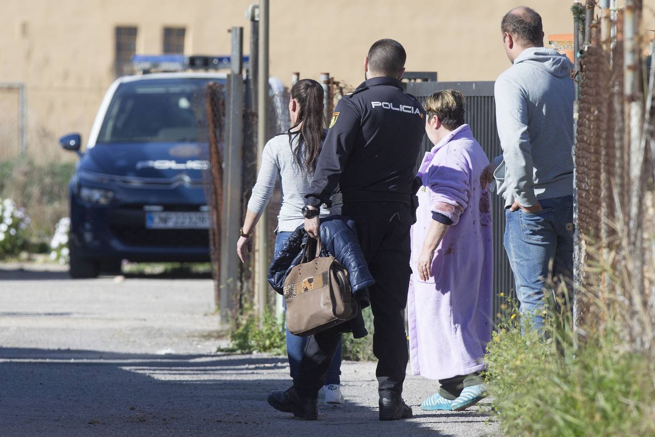 Agentes de la Policia Nacional ante la vivienda junto a la pareja del hombre que supuestamente ha matado con un arma blanca al padre de ésta, en el Grao de Castellón. La mujer le había denunciado por amenazas de muerte y estaba refugiada en un centro de acogida. El arrestado también ha herido a la hija de su expareja, según han confirmado fuentes de la investigación. 