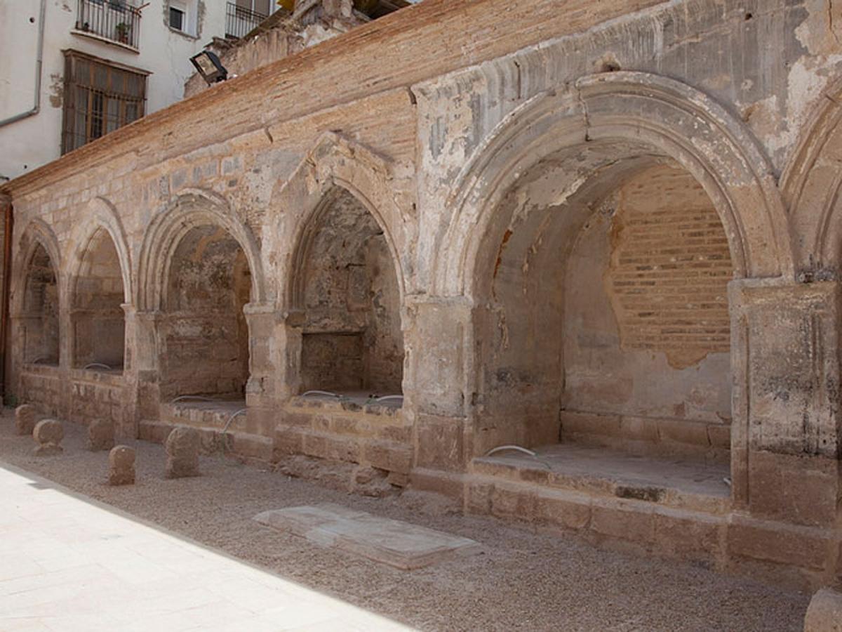 Cripta de Santa Bárbara | Tras enviudar, la emperatriz Constanza de Grecia llegó a Valencia y fue acogida por el rey Jaime I. Un día, Constanza paseaba con su caballo por la iglesia de San Juan del Hospital. En un determinado momento, el equino indicó tercamente con la cabeza un lugar en el suelo, en el que, excavando, apareció una imagen de Santa Bárbara. Por aquel entonces, la emperatriz padecía lepra, así que cogió la imagen, la lavó en un barreño y con ese mismo agua se mojó el cuerpo, sanando completamente de su enfermedad. En agradecimiento a su milagrosa curación, ella misma mandó erigir en honor a Santa Bárbara una capilla en en el lateral sur del presbiterio. La emperatriz dispuso ser enterrada en San Juan del Hospital, junto a la mencionada cripta de Santa Bárbara.