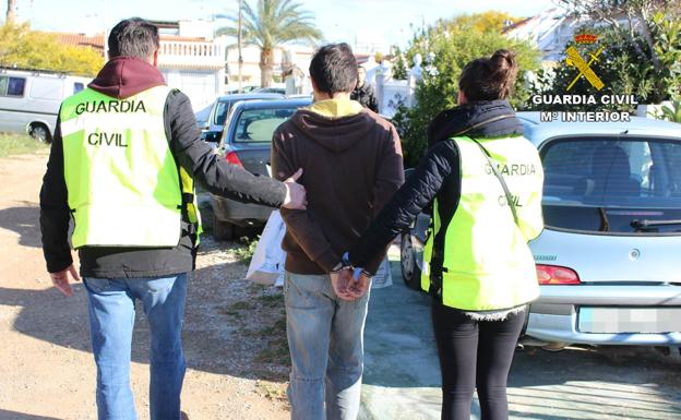 Uno de los detenidos es custodiado por los agentes. 