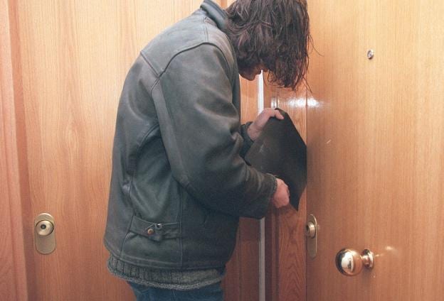 Simulación de un hombre intentando forzar una puerta con una radiografía. 