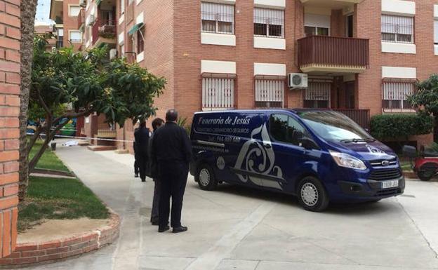 Vehículo de la funeraria en la puerta del inmueble donde ha tenido lugar el presunto crimen. 