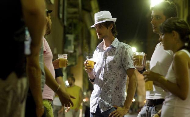 Jóvenes beben cerveza en el centro de Milán. 