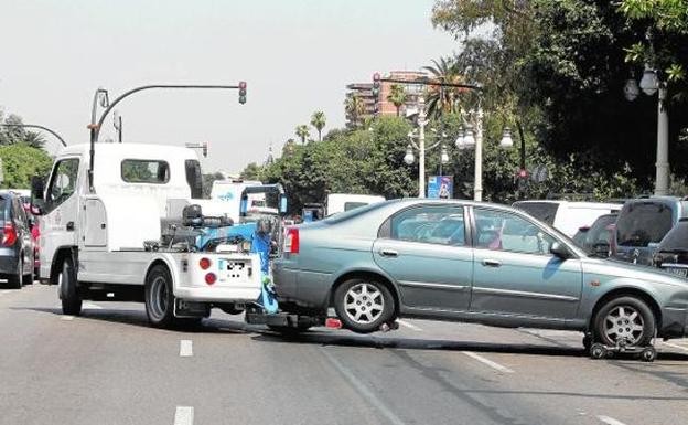 Una grúa retira un coche mal aparcado. 