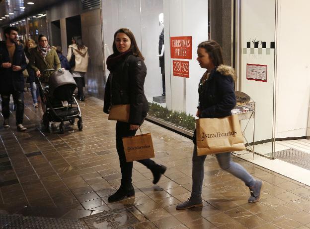 Dos jóvenes, de compras, en el centro de Valencia. 