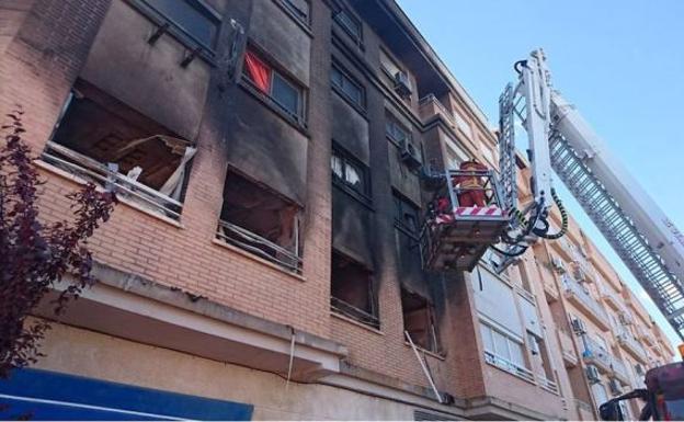 Un bombero ante la vivienda calcinada en Albal.