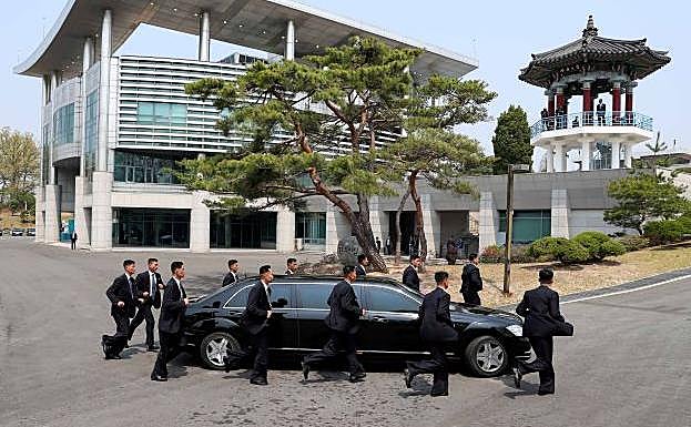 Los guardaespaldas de Kim Jong-un acompañan la limusina en la que viaja el líder político.