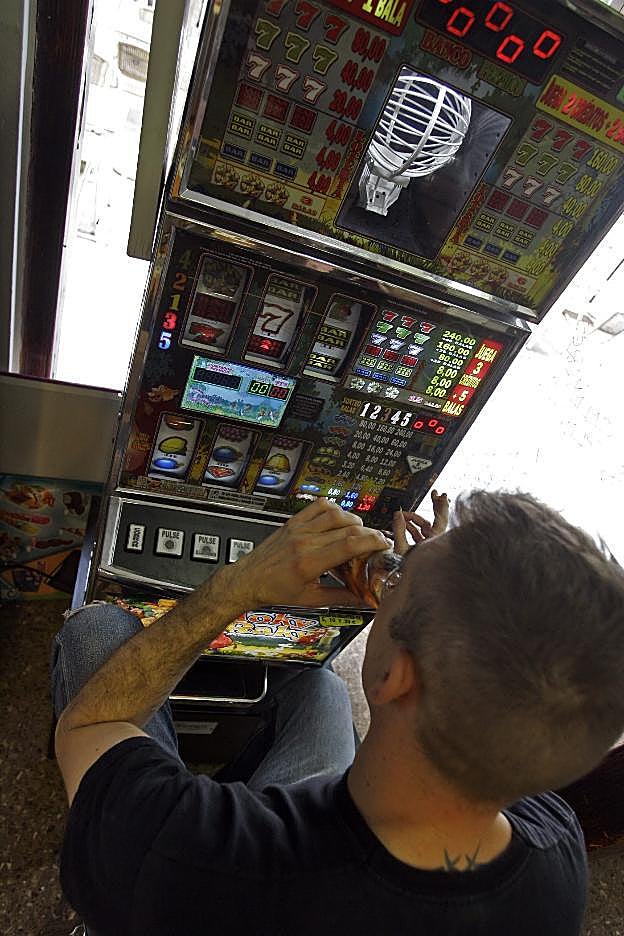 Un cliente juega en un máquina de juego. 