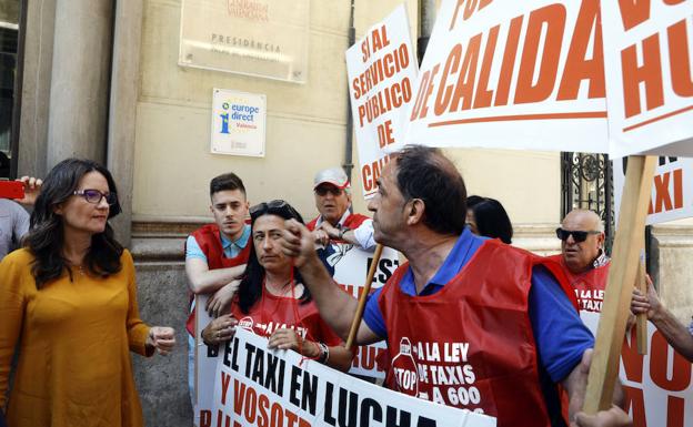 Los taxistas abordan a Mónica Oltra tras el pleno del Consell para mostrar su enfado por la ley del taxis