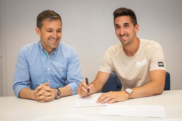 Oier firma su nuevo contrato ayer en presencia de Vicente Blanco 'Tito'. 