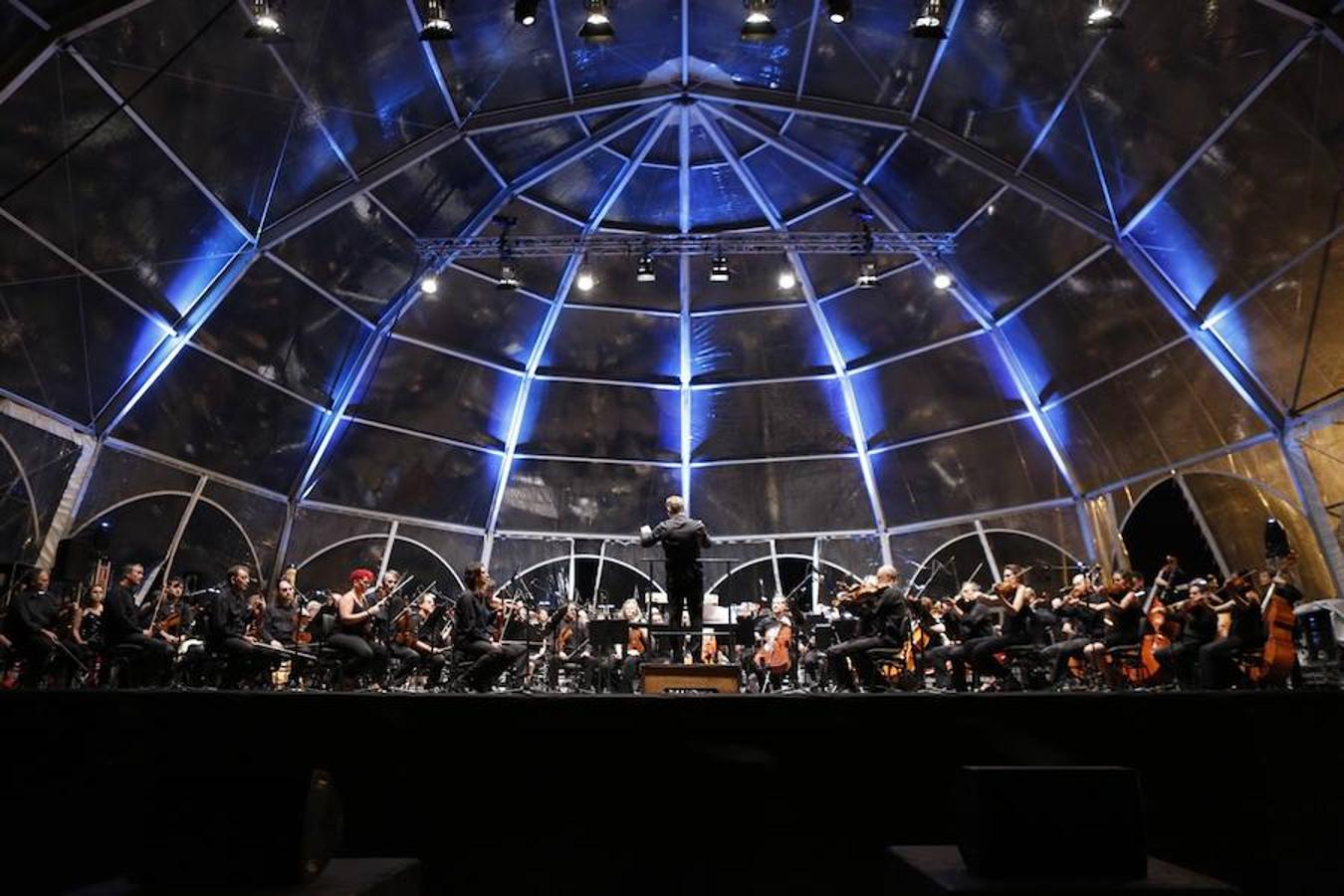 La Orquesta de Valencia hace historia junto al mar. Por primera vez, cierra la temporada en la playa de Las Arenas en un espectáculo para más de 1.000 personas. Un escenario de 300 metros y una cúpula transparente sirve de foco de atracción para el numeroso público congregado en la noche de este viernes en la playa. El concierto se ha bautizado con el nombre de 'Música i Aigua amb l'Orquesta de València'.