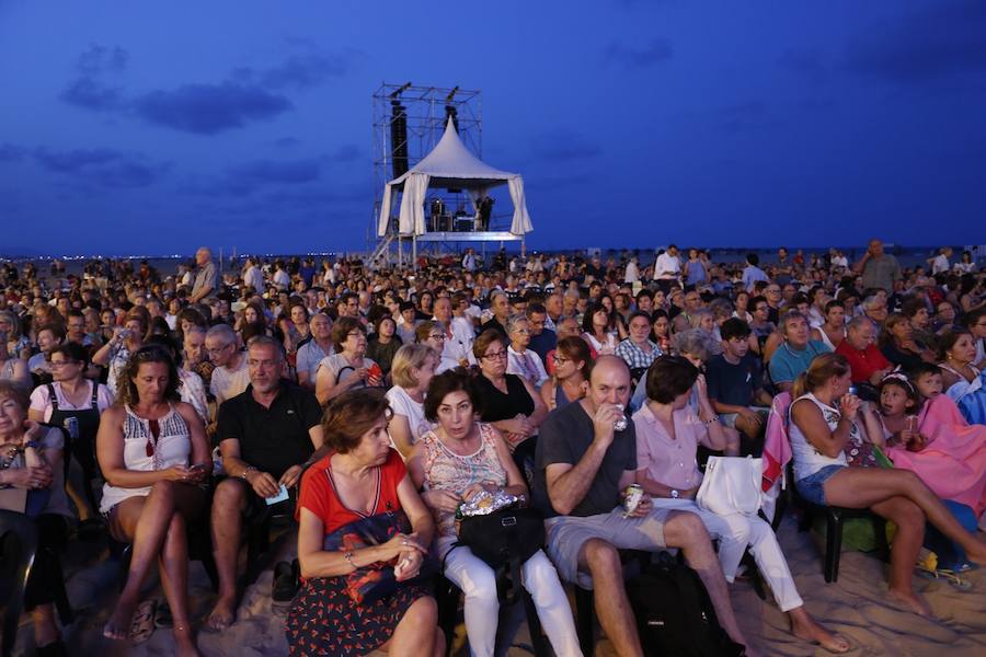 La Orquesta de Valencia hace historia junto al mar. Por primera vez, cierra la temporada en la playa de Las Arenas en un espectáculo para más de 1.000 personas. Un escenario de 300 metros y una cúpula transparente sirve de foco de atracción para el numeroso público congregado en la noche de este viernes en la playa. El concierto se ha bautizado con el nombre de 'Música i Aigua amb l'Orquesta de València'.