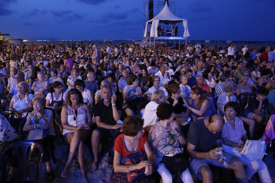 La Orquesta de Valencia hace historia junto al mar. Por primera vez, cierra la temporada en la playa de Las Arenas en un espectáculo para más de 1.000 personas. Un escenario de 300 metros y una cúpula transparente sirve de foco de atracción para el numeroso público congregado en la noche de este viernes en la playa. El concierto se ha bautizado con el nombre de 'Música i Aigua amb l'Orquesta de València'.