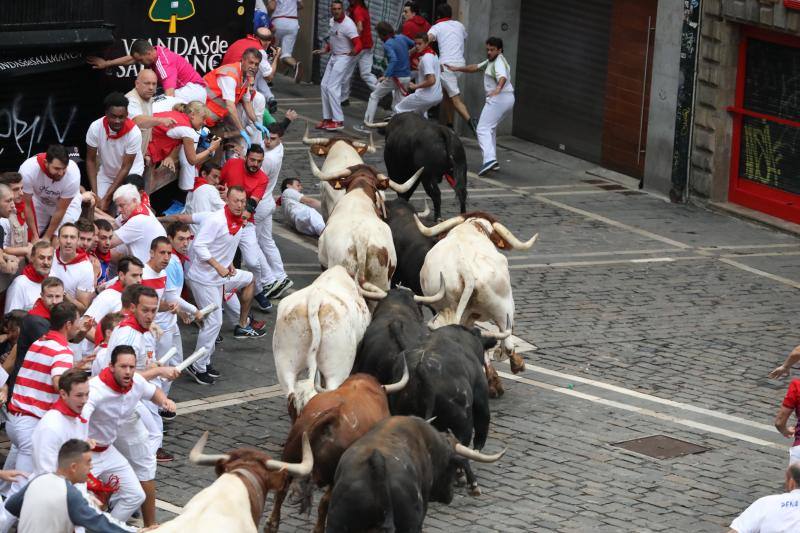 Al llegar a la zona del Ayuntamiento, este toro negro ha golpeado a varios corredores y ha embestido al final a un mozo cuya faja se ha quedado enganchada en el cuerno del astado. Ha sido arrastrado unos metros hasta que se ha desenganchado y el toro negro ha continuado la carrera todavía con la faja roja colgando de su cuerno.