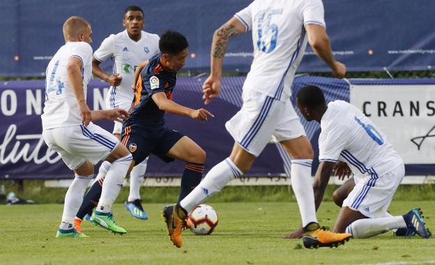 Kangin Lee, rodeado de rivales en su debut en el primer equipo del Valencia contra el Laussane. 