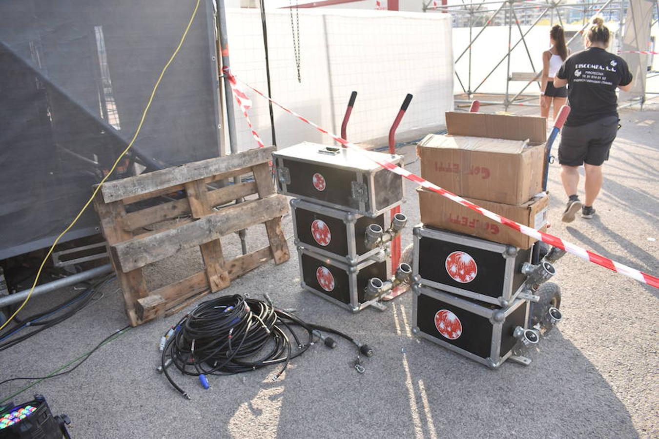 En la zona, completamente acordonada, los cables reposan en medio del asfalto junto a tablas de madera o focos por colocar, mientras la música suena de fondo después de ensayos de sonido a primera hora de la tarde.