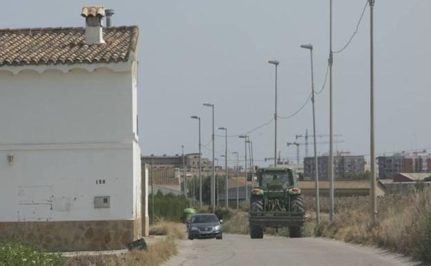 Una carretera que discurre entre las últimas huertas de Valencia