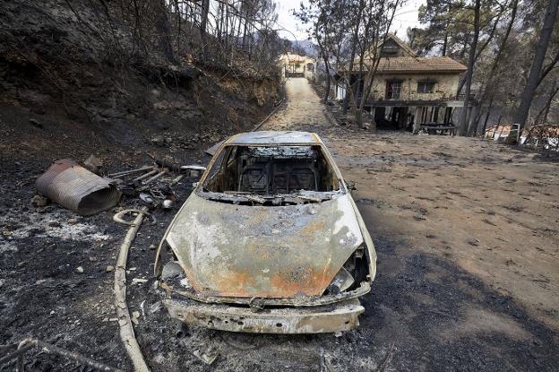 Un vehículo totalmente calcinado en la urbanización Las Cumbres de Gandia, ayer. 