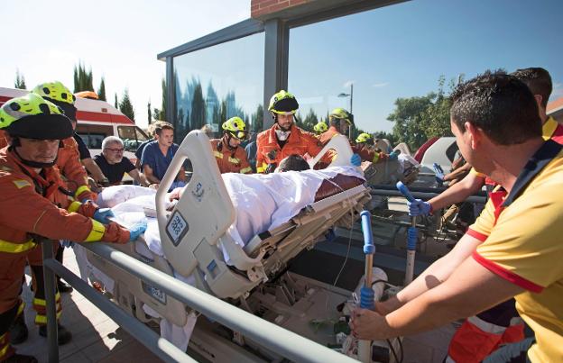 Los bomberos trasladan a Teófilo con una cama especial. 