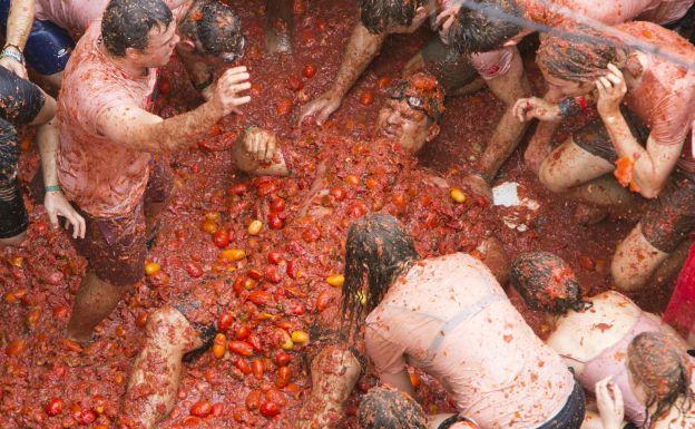 Un hombre tirado en el suelo cubierto de tomates durante la Tomatina del año pasado.