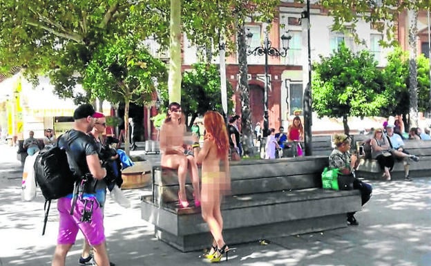 Dos actrices desnudas charlan en una pausa de un rodaje en una plaza sevillana 