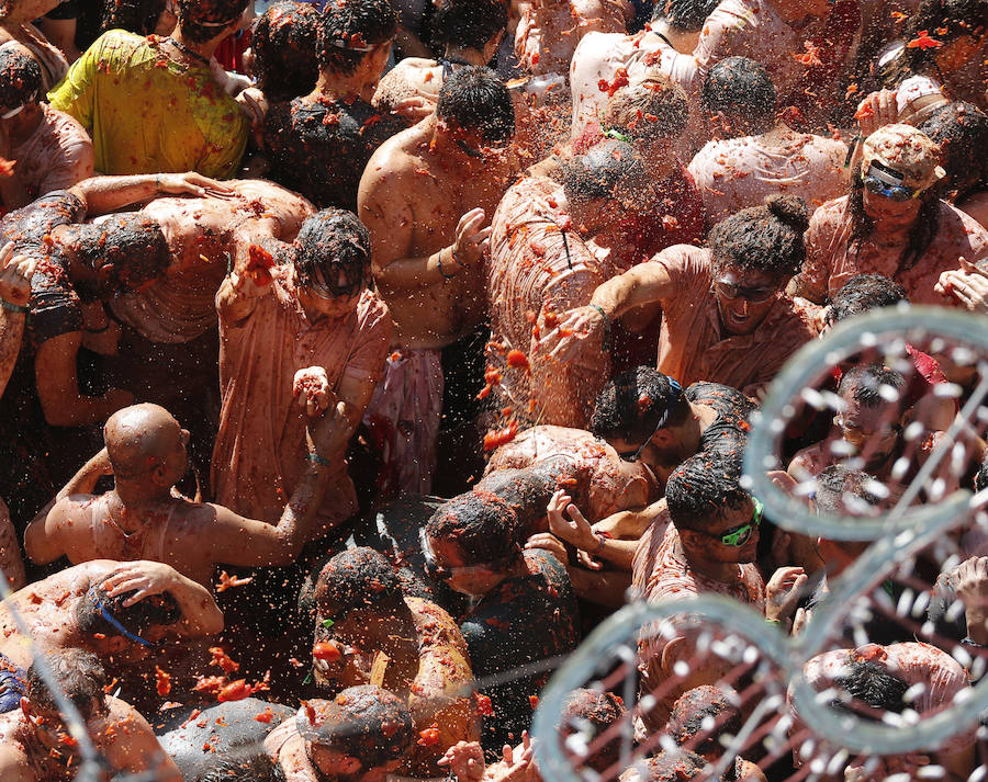 Buñol ha vivido este miércoles su fiesta más internacional. La Tomatina 2018 ha reunido a 20.000 personas que se han lanzado 145.000 kilos de tomate en la batalla menos cruenta de la historia. Ataviados con ropa vieja, gafas protectoras o chubasqueros, extranjeros y locales han disfrutado a tope de una fiesta que, además de diversión, genera un importante retorno económico a la localidad. 