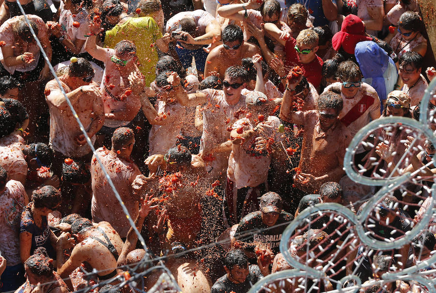 Buñol ha vivido este miércoles su fiesta más internacional. La Tomatina 2018 ha reunido a 20.000 personas que se han lanzado 145.000 kilos de tomate en la batalla menos cruenta de la historia. Ataviados con ropa vieja, gafas protectoras o chubasqueros, extranjeros y locales han disfrutado a tope de una fiesta que, además de diversión, genera un importante retorno económico a la localidad. 