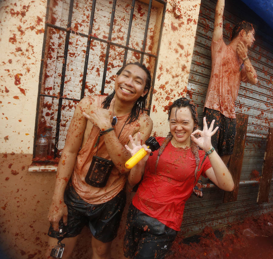 Buñol ha vivido este miércoles su fiesta más internacional. La Tomatina 2018 ha reunido a 20.000 personas que se han lanzado 145.000 kilos de tomate en la batalla menos cruenta de la historia. Ataviados con ropa vieja, gafas protectoras o chubasqueros, extranjeros y locales han disfrutado a tope de una fiesta que, además de diversión, genera un importante retorno económico a la localidad. 