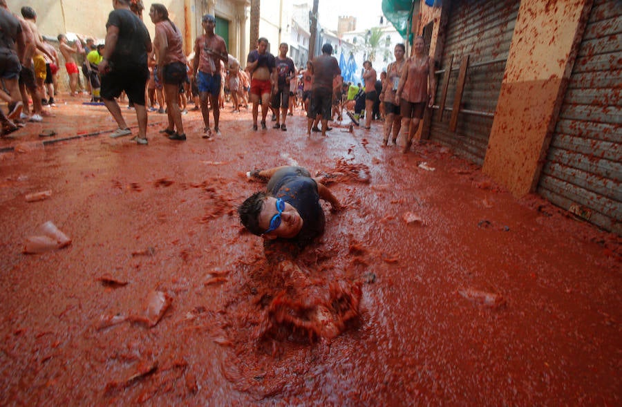 Buñol ha vivido este miércoles su fiesta más internacional. La Tomatina 2018 ha reunido a 20.000 personas que se han lanzado 145.000 kilos de tomate en la batalla menos cruenta de la historia. Ataviados con ropa vieja, gafas protectoras o chubasqueros, extranjeros y locales han disfrutado a tope de una fiesta que, además de diversión, genera un importante retorno económico a la localidad. 