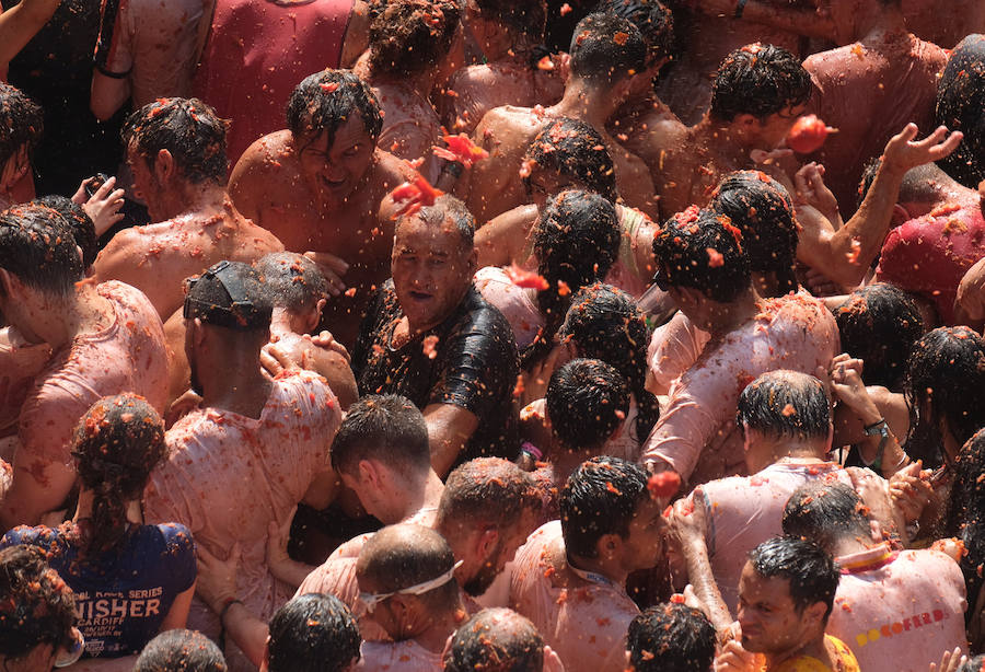 Buñol ha vivido este miércoles su fiesta más internacional. La Tomatina 2018 ha reunido a 20.000 personas que se han lanzado 145.000 kilos de tomate en la batalla menos cruenta de la historia. Ataviados con ropa vieja, gafas protectoras o chubasqueros, extranjeros y locales han disfrutado a tope de una fiesta que, además de diversión, genera un importante retorno económico a la localidad. 