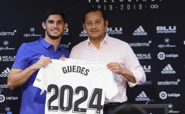 Guedes posa con la camiseta junto al presidente Anil Murthy. 