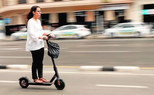 Una mujer en patinete.