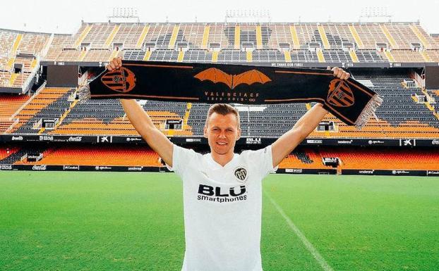 Cheryshev posa con la camiseta y la bufanda del Valencia.