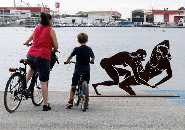 Dos ciclistas contemplan una de las piezas de Miró. 