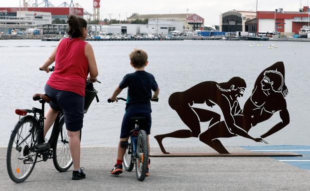 Galería. Una mujer y un niño observan una de las esculturas sexuales en la Marina de Valencia.