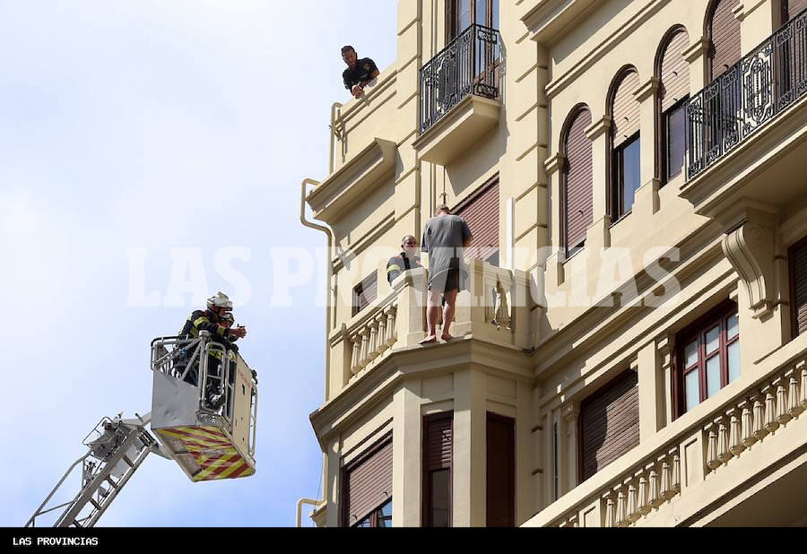 Fotos: Rescatado un hombre que amenaza con lanzarse al vacío desde un edificio del centro de Valencia