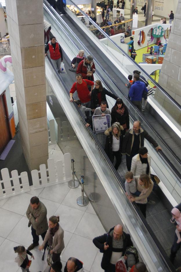 Personas en el interior de un centro comercial. 