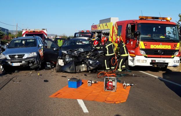 Bomberos de Castellón trabajan en el rescate de una de las víctimas del accidente mortal de Benicàssim, el domingo, en la carretera N-340. 