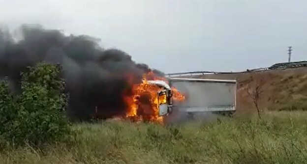 El vehículo, en llamas, junto a la carretera CV-50.