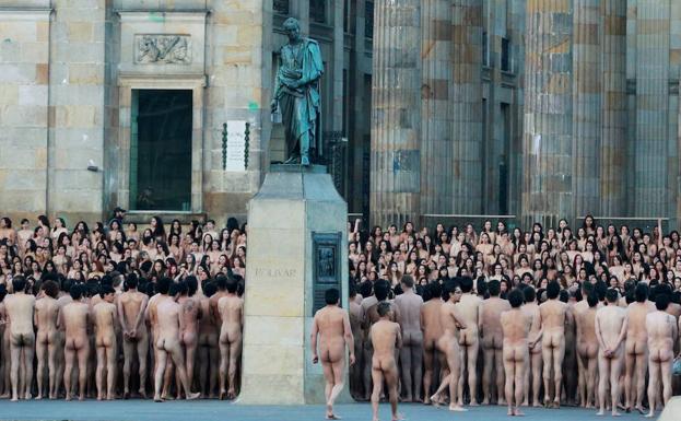 Imagen principal - Personas desnudas en Bogotá (Colombia). Modelos desnudos en el Mar Muerto. Ambas instántaneas del fotográfo Spencer Tunick, que sostiene un premio en la fotografía 