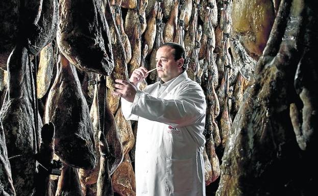 José Gómez comprueba la maduración de los jamones en una bodega.