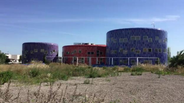 El exterior de los edificios de la superguardería, rodeado de matojos. 