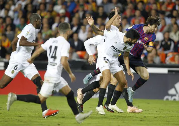 Messi intenta colarse entre Parejo y Garay. 