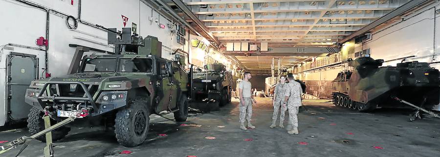 El personal de Infantería de Marina delante del dique inundable para el desembarco de unidades anfibias y junto a los vehículos pesado que se guardan en este hangar. 