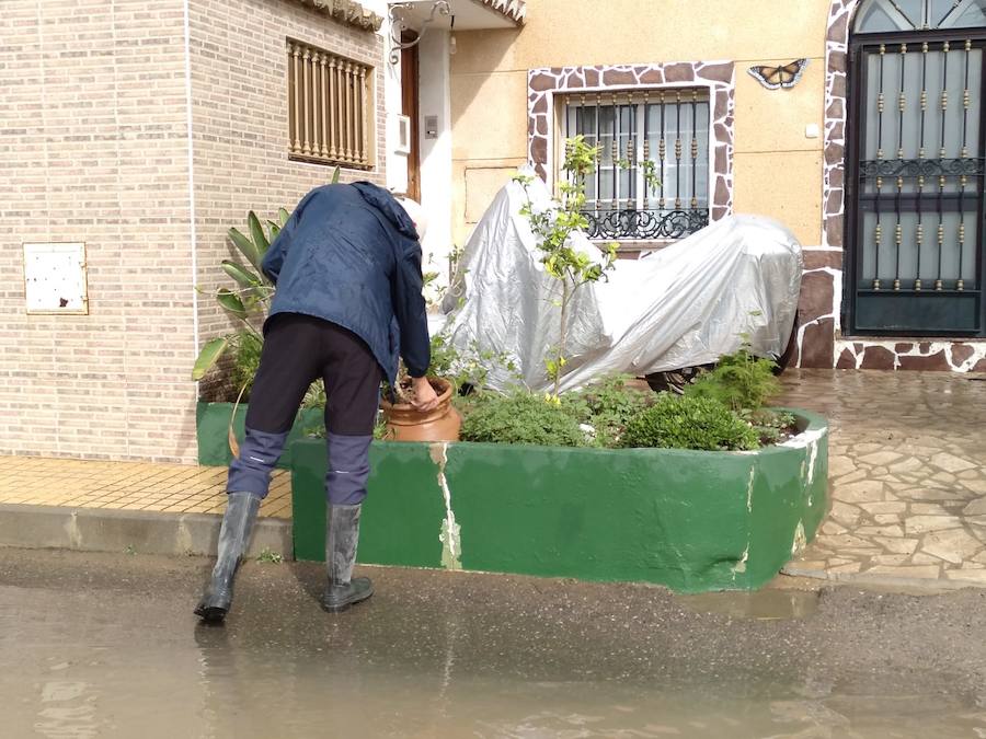 Vecino del Camí de Barranquet limpiando su jardín tras las lluvias 