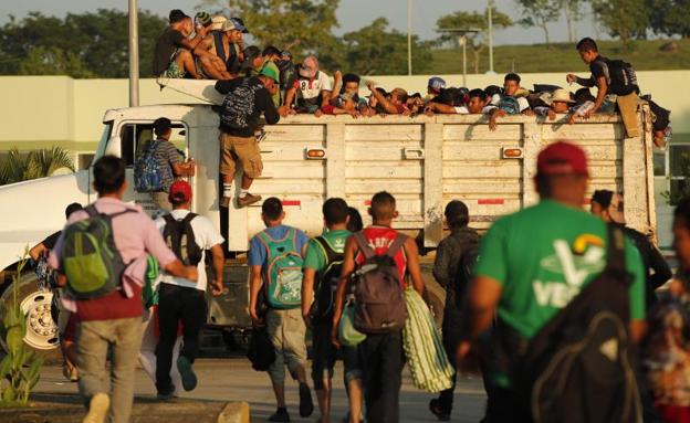 Migrantes hondureños suben a un camión.