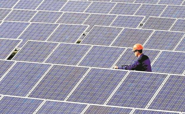 Trabajador inspeccionando los paneles de una planta solar 